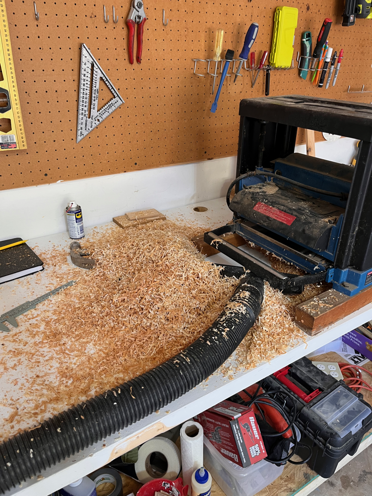 Photo of electric planer in use, with lots of wood shavings